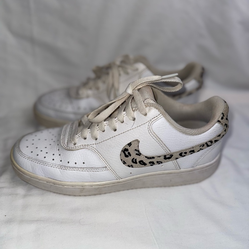 Nike women’s Court Vision Low sneakers in white with a leopard print swoosh